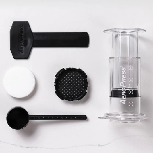 AeroPress coffee brewing device with components on a white background