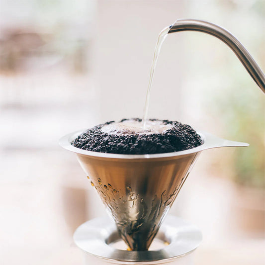 Coffee being poured into a filter with a blurred background