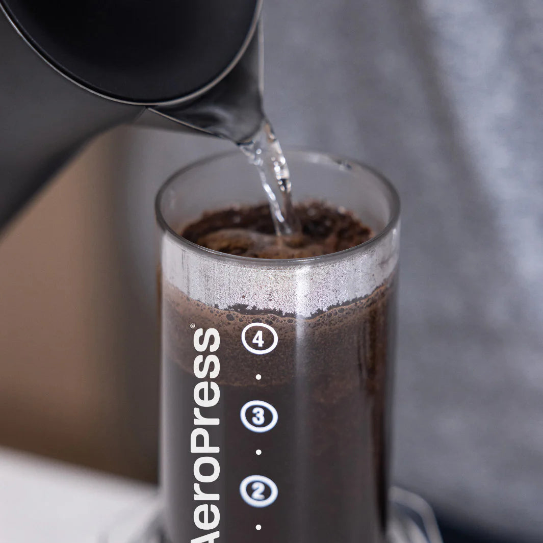 Aeropress coffee maker with coffee being poured into it